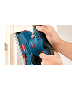 Bosch GSS 23 AE Orbital Sander being held by two hands sanding and door frame. Blue and black casing with red adjustment and power controls.