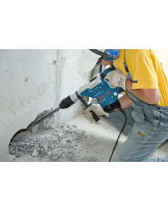A man wearing a yellow shirt and gloves using a Bosch GBH-5-40 DCE Rotary Hammer with SDS Max.