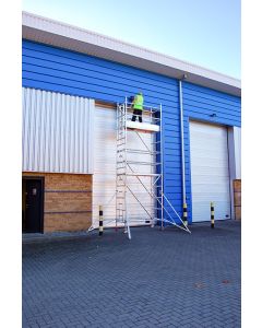 Man stood at the top of Single width Silver scaffold Tower maintaining frontage of industrial unit.