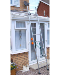 A conservatory ladder positioned against the outside of a conservatory with white blinds and windchime in the window.