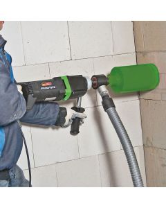 Person wearing yellow protective gloves using a Makita Diamond Core Drill on a brick wall. 